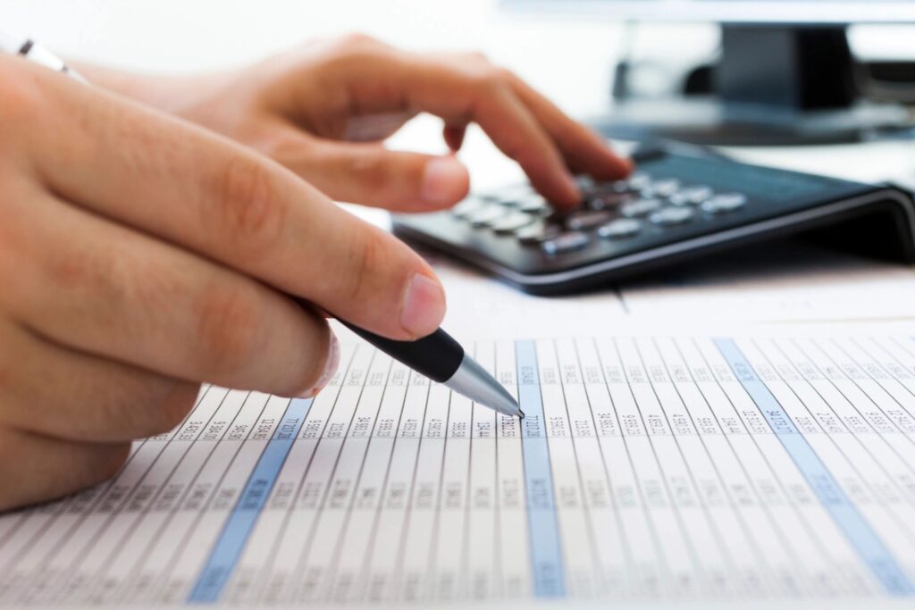 Person calculating roofing expenses for roof repairs and installation services in Los Angeles.