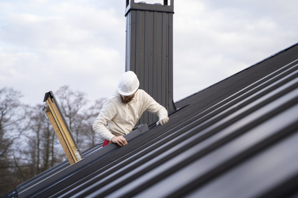 Roofer working on metal roof installation in Los Angeles.